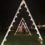 Outdoor wedding reception at The Maples with custom made triangle arches with market string lighting following interior outline of each arch.